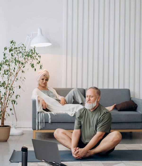 Mujer en una postura de yoga tranquila en una habitación luminosa y minimalista.